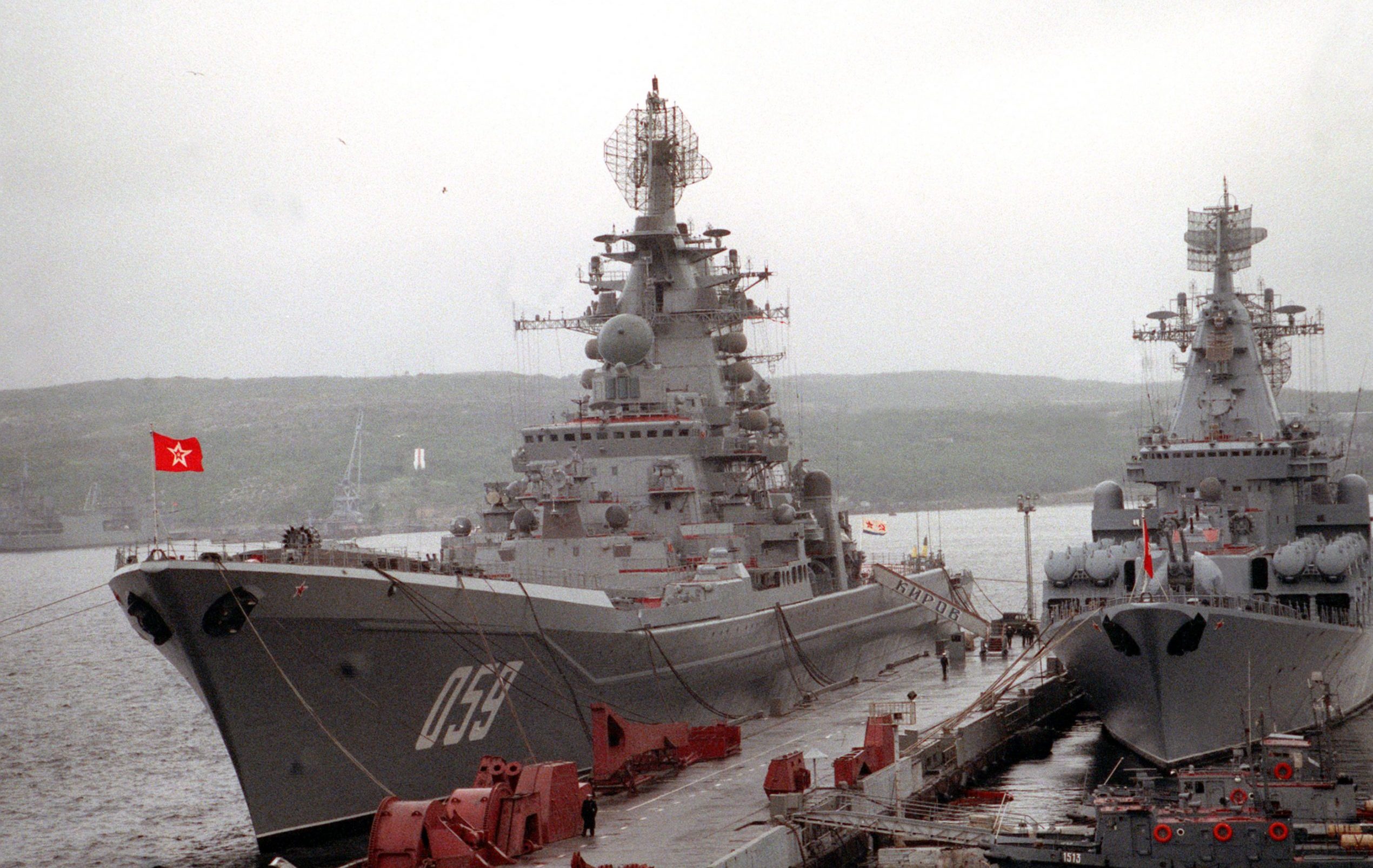 The Russian nuclear-powered guided missile cruiser ADMIRAL USHAKOV, left, still bearing its original name, KIROV, on the gangplank, and the guided missile cruiser MARSHAL USTINOV stand moored to a pier during a port call by two American ships.  The Guided missile cruiser USS YORKTOWN (CG-48) and the destroyer USS O'BANNON (DD-987) are visiting Severomorsk as part of an ongoing exchange between the navies of the United States and the Commonwealth of Independent States.