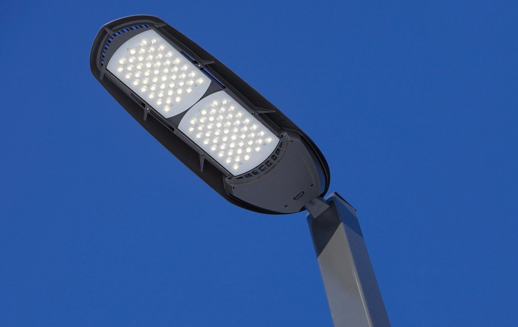 Illuminated LED Streetlight against a Clear Blue Sky