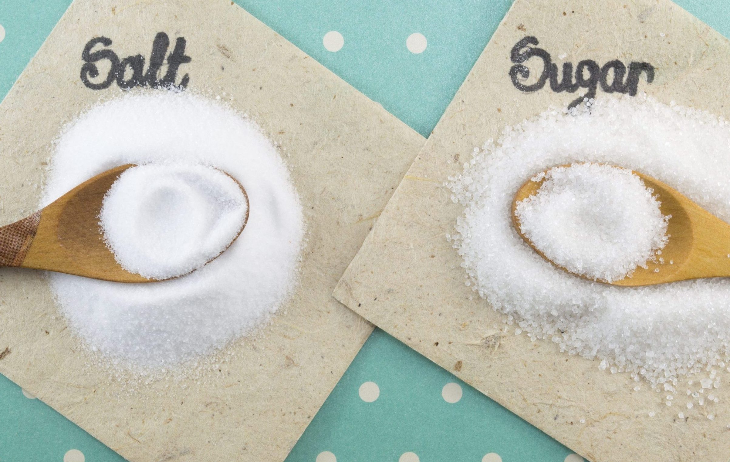 Spoons full of salt and sugar on a colorful background